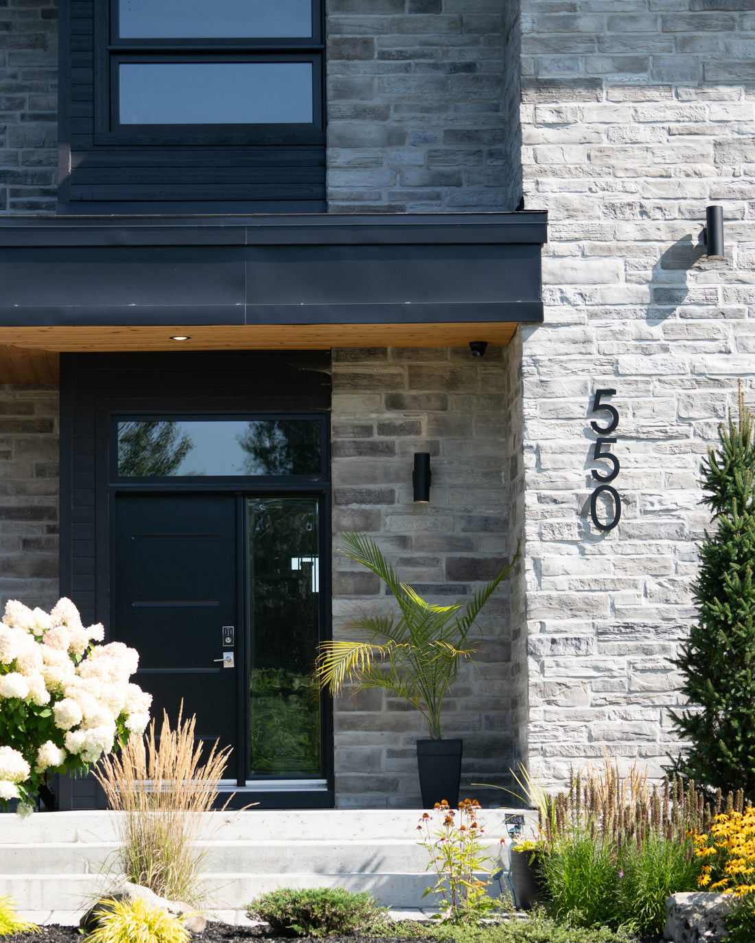 Numéro de porte flottant noir installé sur une façade moderne